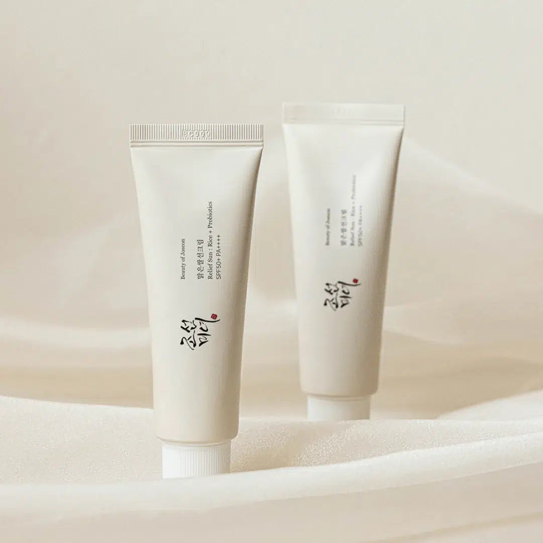 Two white skincare tubes with text on a beige background